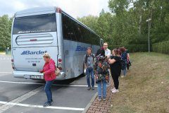 Uczestnicy wycieczki stoją obok autobusu, którym dojechali na Górę Kamieńską